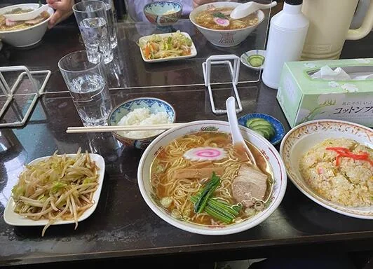 ラーメン、チャーハン、炒めものが並ぶ食卓